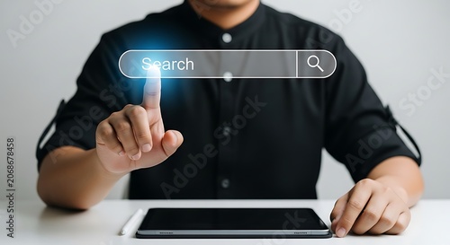 Person's finger touching a glowing search bar on a digital interface, tablet below searching internet