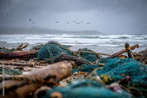 Discarded fishing nets on a windswept shoreline signal ghost-net pollution and marine danger