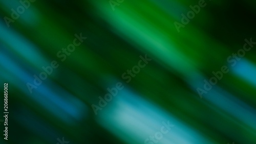 Close-up of vibrant green palm leaves with motion blur effect and natural sunlight illuminating