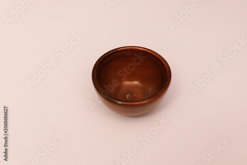 A small brown bowl sits on a light background for serving food or as decoration