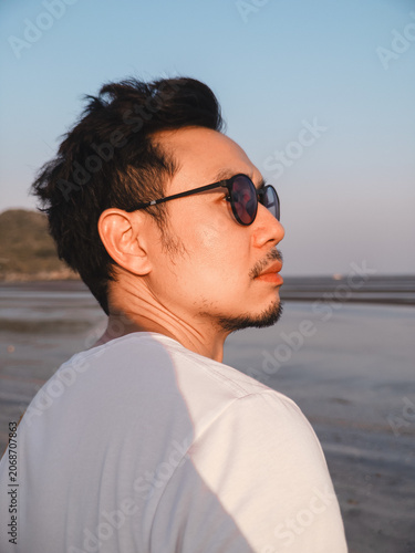 Valokuva Person wearing shades gazes over faraway water peacefully
