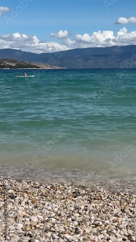 Pebble beach and turquoise sea with mountain view