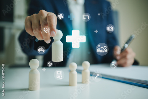 Obraz na plátně Life insurance protection with businessperson selecting family figurine for heal