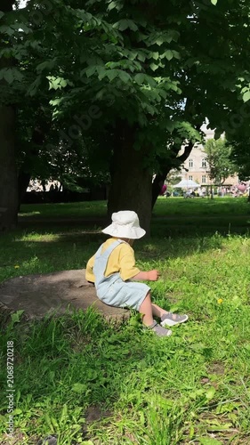 Happy toddler walking in park under green tree