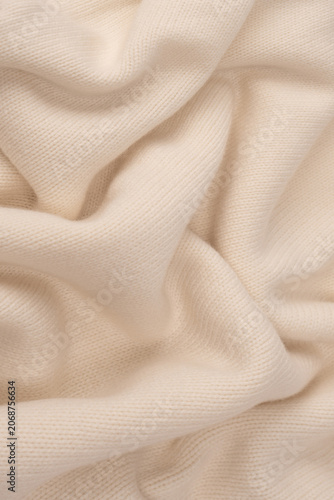 Soft milky color merino wool sweater texture as a background.