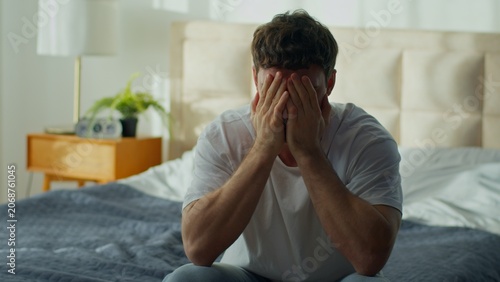 Angry Caucasian man receiving bad news on smartphone feeling frustrated male throwing mobile phone at home bedroom guy upset by notification bankruptcy divorce irritation stress problem crisis indoors