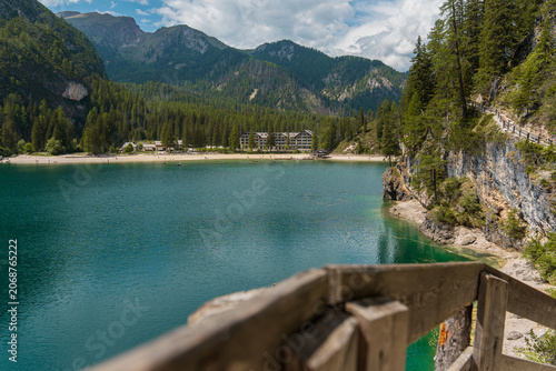 Foto Scenic hiking path with wooden handrail along turquoise waters of Lake Braies, s