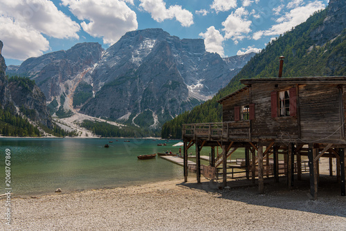 Bild auf Leinwand Rustic wooden boathouse on stilt pillars by the gravel shore of Lake Braies with