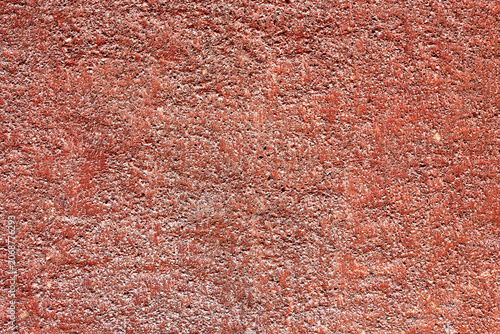 Rough reddish-brown concrete wall texture detail under natural daylight