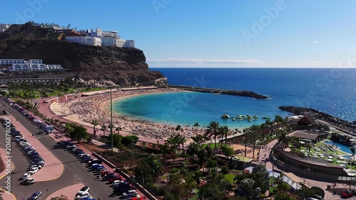 Tableau sur toile Coastal city with beach, harbor, and hillside buildings