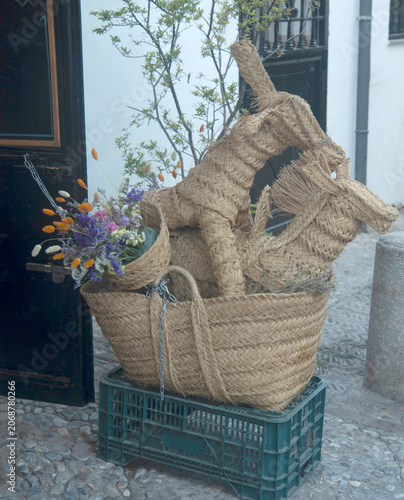 Traditional woven esparto grass donkey,  horse figurines and basket with flowers, Spanish rustic decor