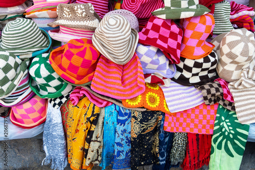 Fotografía Colorful handmade crochet bucket hats and traditional batik sarongs displayed at a local market