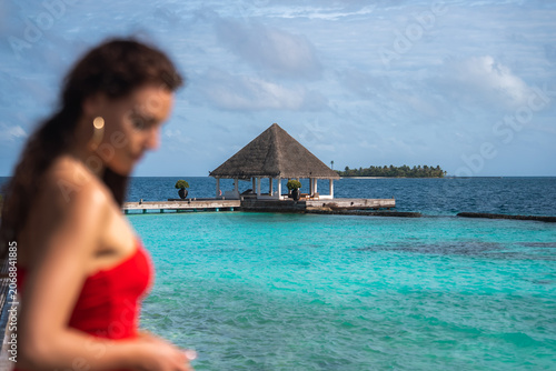 Bild auf Leinwand Turquoise lagoon leads to a wooden thatched pavilion on a pier near Male