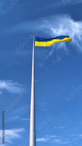 Ukrainian national flag waving on high flagpole