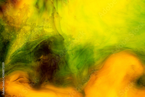 Fotografía Abstract background of yellow and green ink swirling in water, creating vibrant