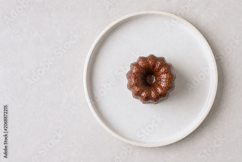 お皿に載ったフランスの伝統菓子カヌレ、おしゃれなフードスタイリングの物撮り素材