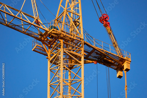 Abstract industrial composition of an orange crane jib and sky