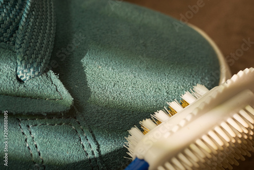 Bristle brush demonstration. Device effectively cleans sneaker seams from dirt. Closeup of bristle tool scrubbing textured suede material
