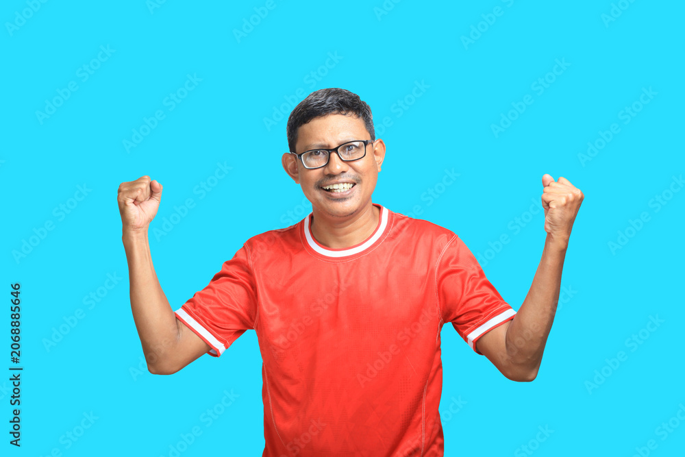 Fototapeta premium Expressive Asian man wearing red t-shirt and glasses gesturing on blue background