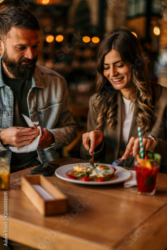 Tableau sur toile Couple enjoying brunch and conversation at a restaurant