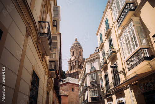 Historic Malaga street with cathedral tower and balconies