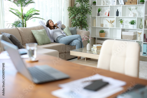 Teleworker taking a break and resting on a couch at home