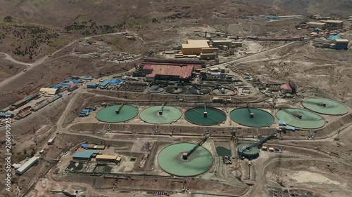 Wide cinematic drone orbit showcasing the full magnitude of tailings management infrastructure at a large Chilean copper mining operation. The sweeping aerial perspective emphasizes engineering precis