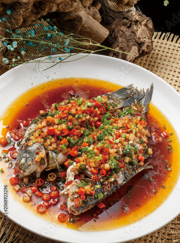 Double-pepper crucian carp served on a white round porcelain plate
