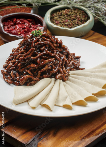 Shredded pork with sweet bean sauce served on a round white porcelain plate