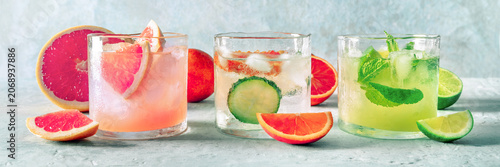 Refreshing summer cocktails with ice cubes on a light background