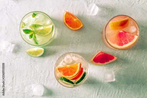 Refreshing summer cocktails with ice cubes on a light background
