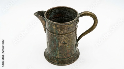 Oxidized metal jug displaying heavy verdigris patina on a white studio background with sharp macro focus for antique retail advertising