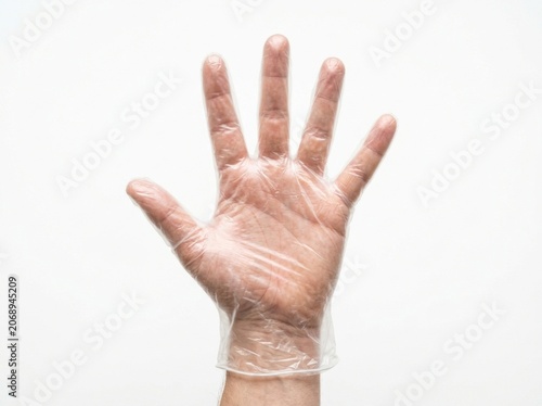 Clear polyethylene glove on outstretched hand isolated on white background in sharp studio macro photography for professional healthcare and sanitation branding