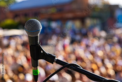 rofessional vocal microphone close up on live concert stage with blurred crowd background