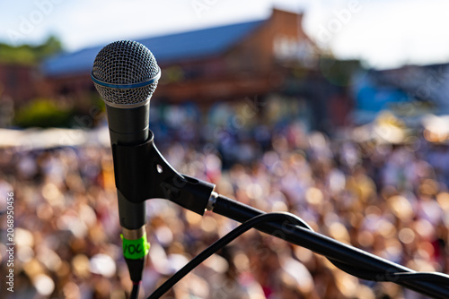 rofessional vocal microphone close up on live concert stage with blurred crowd background