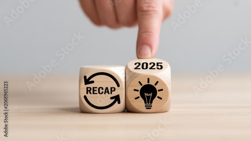 Hand placing 2025 recap wooden block with lightbulb idea concept on table