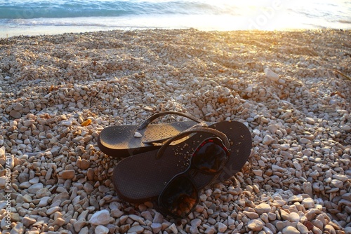 Foto Flip flop sandals and sun glass on the beach by the blue sea summer beach access