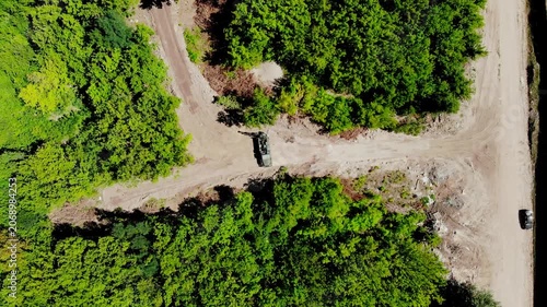 Aerial drone view of a mobile geotechnical drilling rig conducting soil investigation and ground sampling at a future construction site near a forested area in Sumy, Ukraine. The specialized drilling 