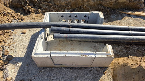 Quadro su tela Precast concrete utility chamber with plastic conduit bundles in an earthen tren