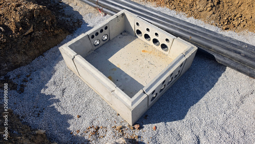 Canvastavla Square precast concrete utility chamber with circular entry ports on a gravel fo