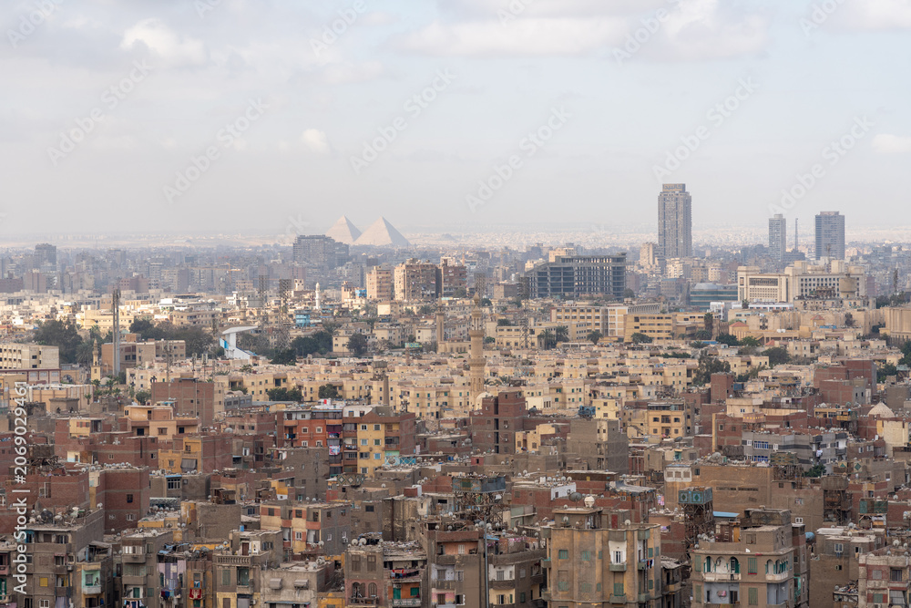 Fototapeta premium Telephoto view of Giza Pyramids and Cairo city skyline