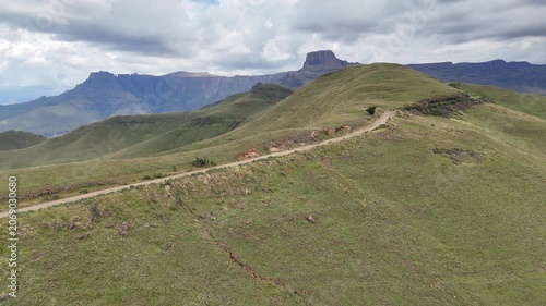 Aerial Ridgewalk Perspective Showing Narrow Trail And Red Earth Leading Over Drakensberg Knoll, Trail Leader