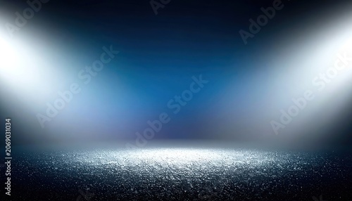 A dark, textured floor is illuminated by two bright spotlights against a deep blue gradient background.