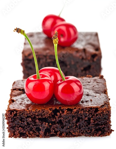 Glossy Red Cherries Resting on Fudgy Chocolate Brownie Pieces on White Background