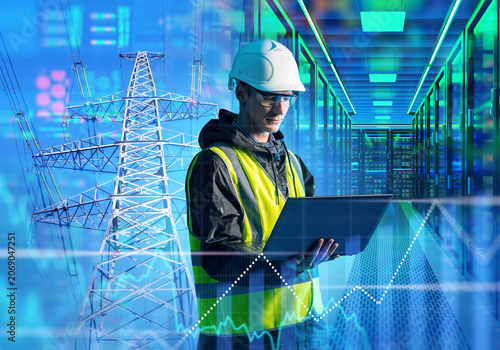 Energy data center. Electrical engineer monitors power grid supply and server infrastructure using laptop in digital control facility