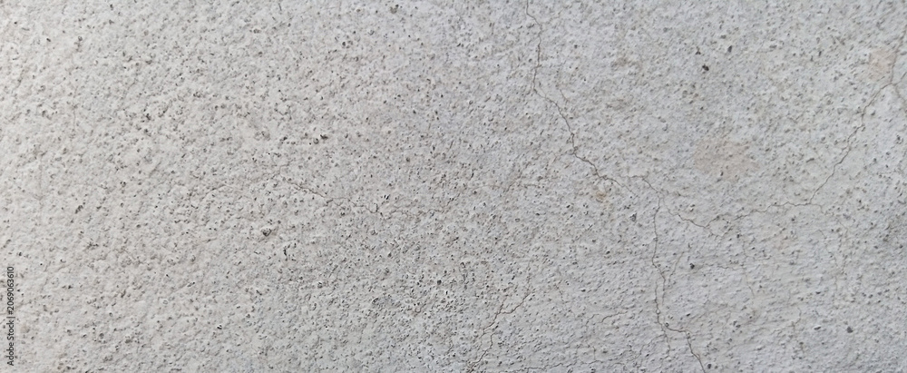 Fototapeta premium Gritty concrete texture background, weathered light gray cement wall surface, industrial stone floor with grainy detail and subtle cracks