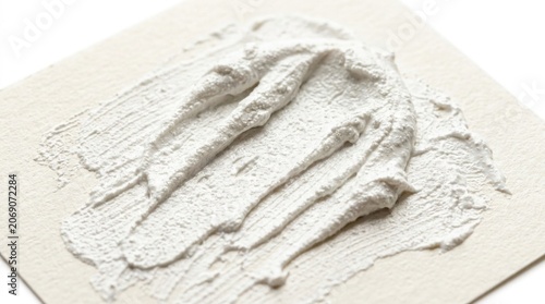White textured cream swatch on beige paper, close-up cosmetic beauty sample