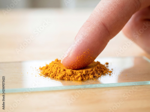 Touching Bright Yellow Spice Glass Surface