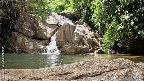 majestic tropical waterfall flowing through lush rainforest in natural wilderness