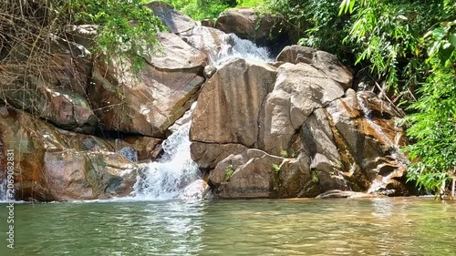 majestic tropical waterfall flowing through lush rainforest in natural wilderness